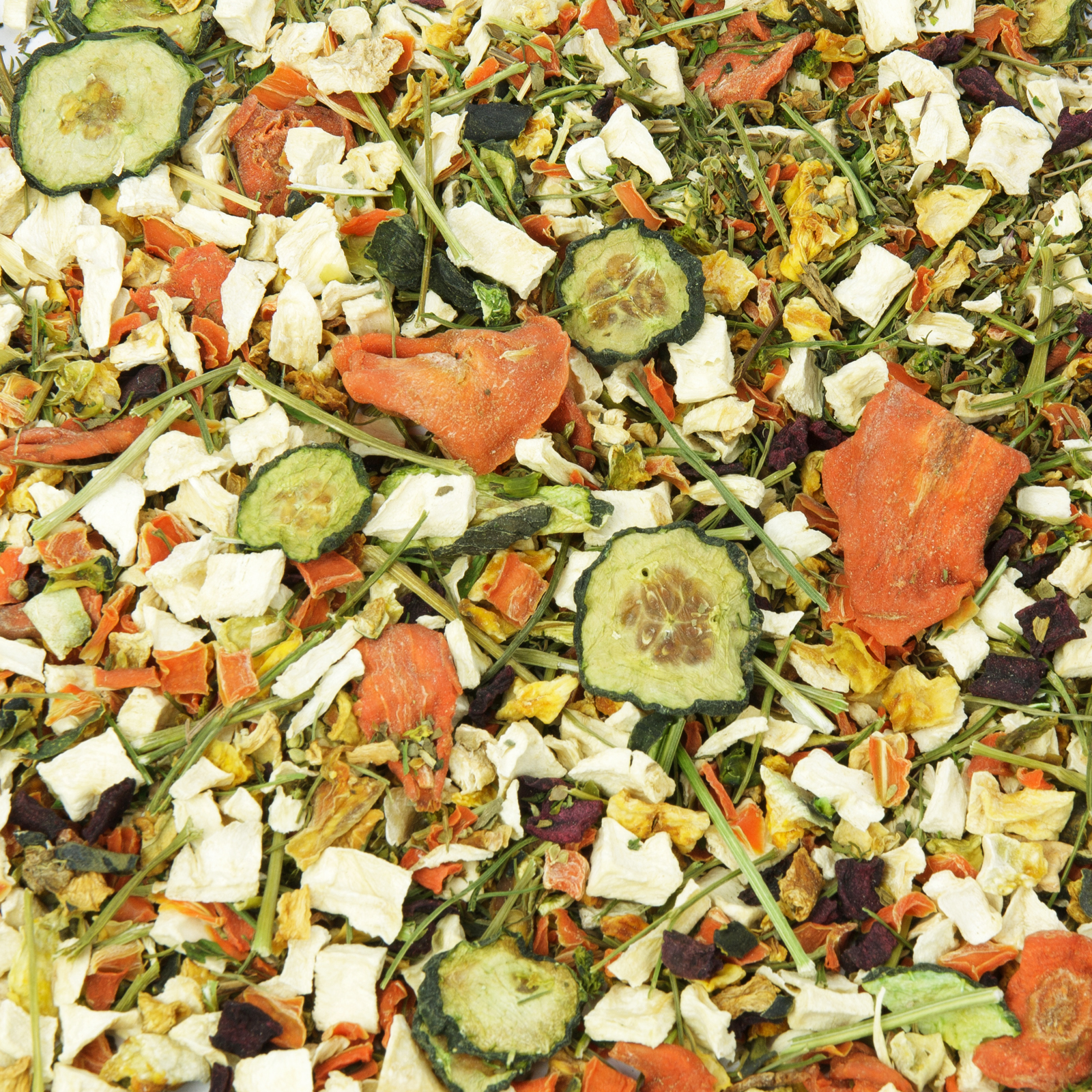 Nahaufnahme einer bunten, getrockneten Gemüsemischung mit Karottenstücken, Zucchinischeiben, Pastinaken- und Rote-Bete-Stückchen sowie Kräuter- und Heustücken