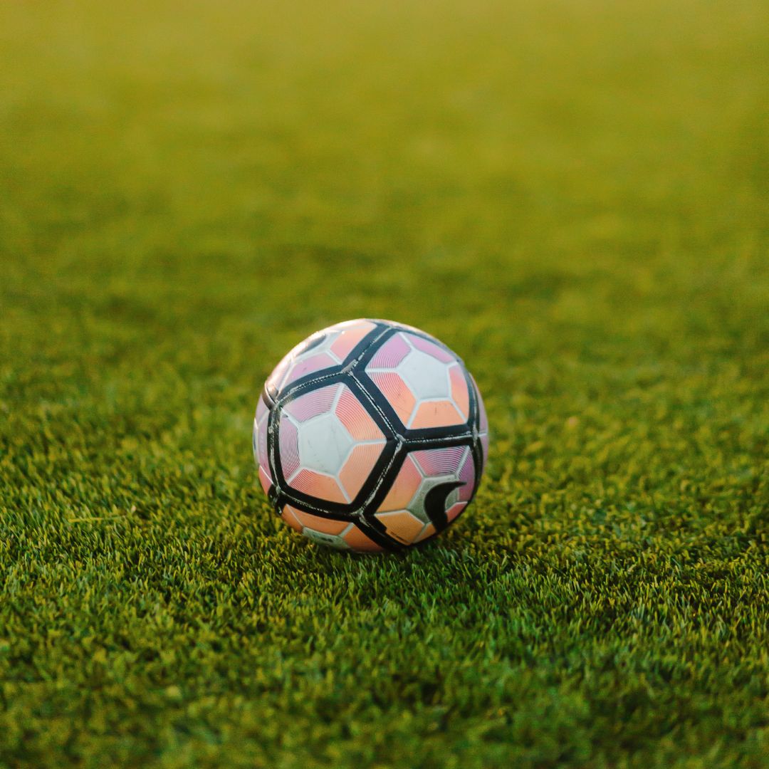Fußball auf intensiv grünem, strapazierfähigem Rasen als Symbol für Rasensamen Top-Sportrasen RSM 2.3, geeignet für Spiel- und Liegewiesen sowie Hausgärten