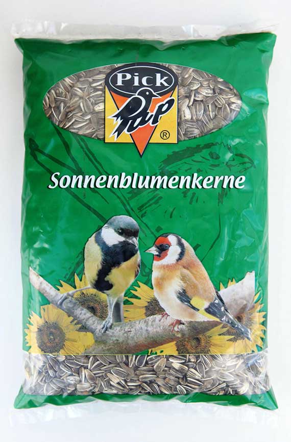 Packung Pick up Sonnenblumenkerne (Vogelfutter) in grüner Folienverpackung mit Sichtfenster, Sonnenblumenillustrationen und Abbildungen einer Meise und eines Stieglitzes