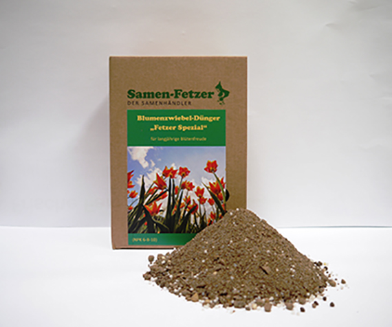 Packung des Samen-Fetzer Blumenzwiebel-Düngers 'Fetzer Spezial' mit braunem Granulat im Vordergrund, Etikett mit Tulpenmotiv vor weißem Hintergrund