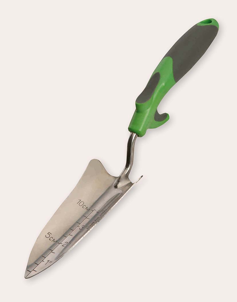 Nahaufnahme einer rostfreien Pflanzkelle mit eingeprägter Maßskala (cm/inch), leicht gezackter Blattkante und ergonomischem grün-grauem Softgrip-Griff auf hellem Hintergrund