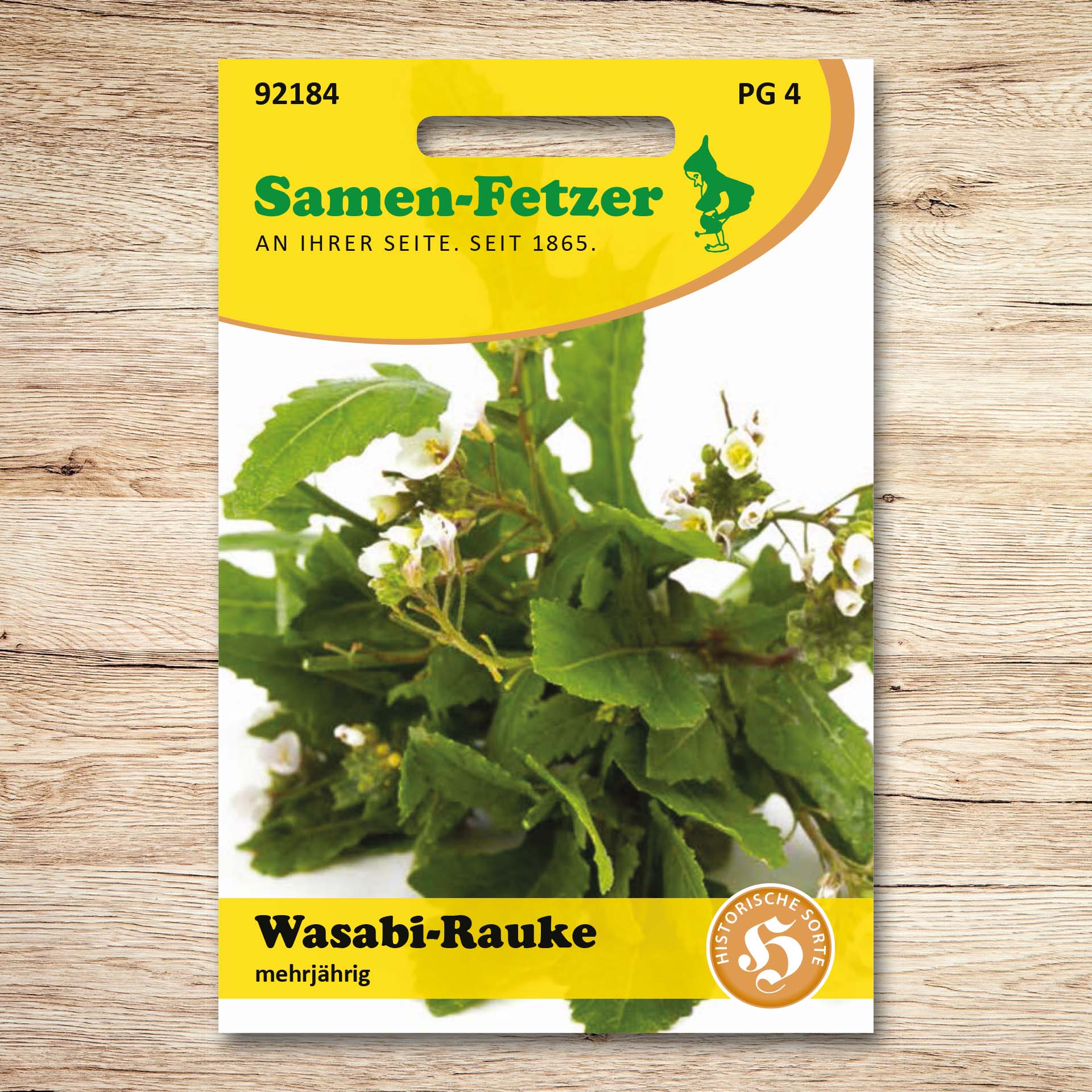 Saatgutpackung Wasabi-Rauke von Samen-Fetzer, mehrjährig, historische Sorte; zeigt grüne Blätter und weiße Blüten, vitaminreiche Rauke mit würzigem Meerretticharoma für Salate, Pesto, Pasta und Suppen