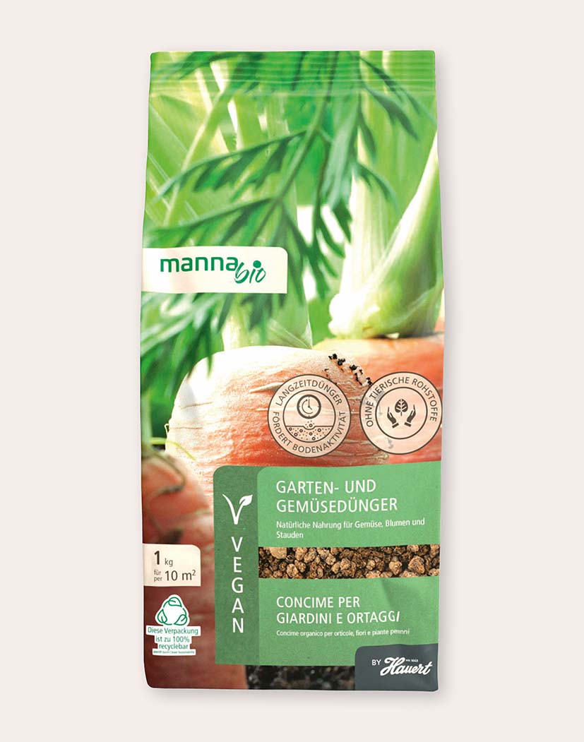 99160_Manna_Bio_Garten-_und_Gemüsedünger Packung Manna Bio Garten- und Gemüsedünger (1 kg) mit grüner Verpackung und Karottenmotiv, Hinweis "vegan", zeigt braunes Granulat zur Düngung von Gemüse und Gartenpflanzen
