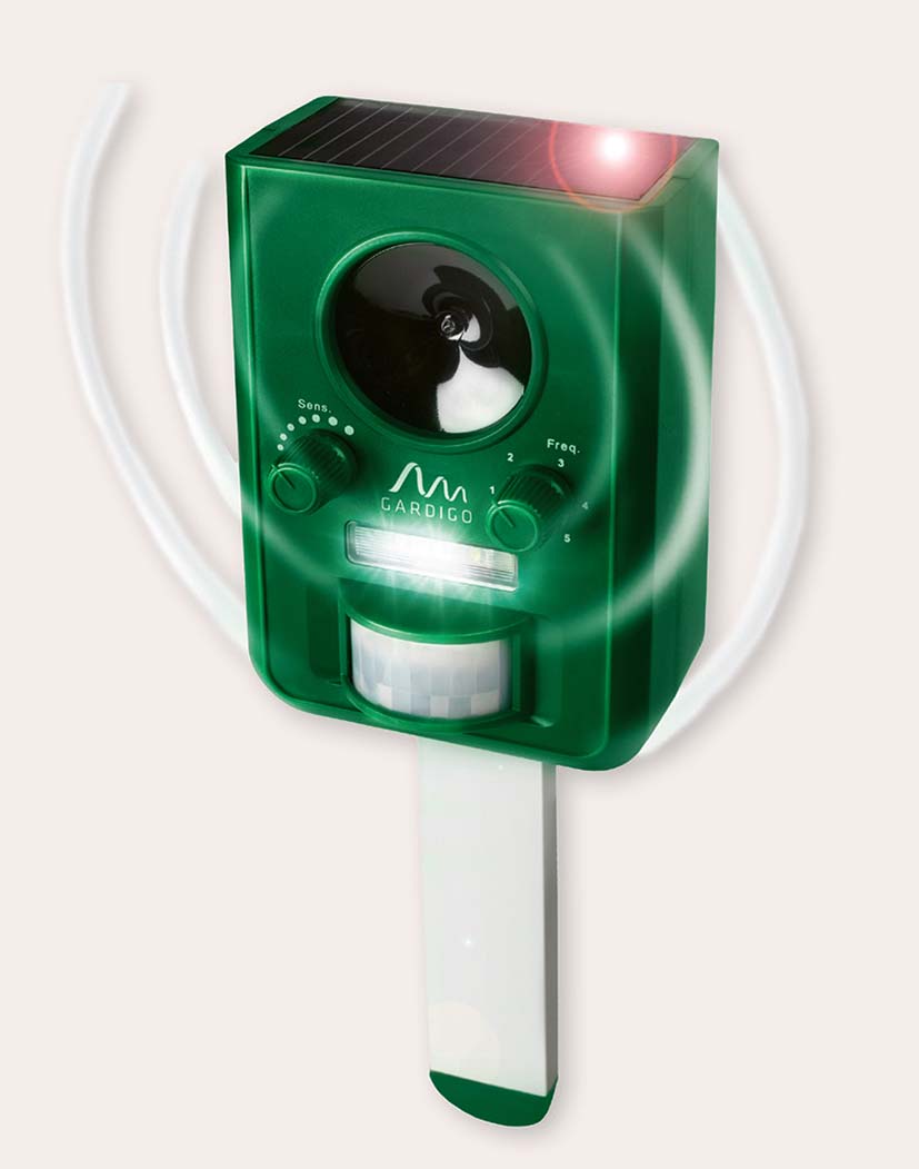 99460_Gardigo_Solar_Tier-Vertreiber Grünes Gardigo-Solargerät zur Tierabwehr mit integriertem Solarpanel, Ultraschalllautsprecher, zwei Einstellreglern, LED-Leuchte und Bewegungsmelder, auf Erdspieß montiert.